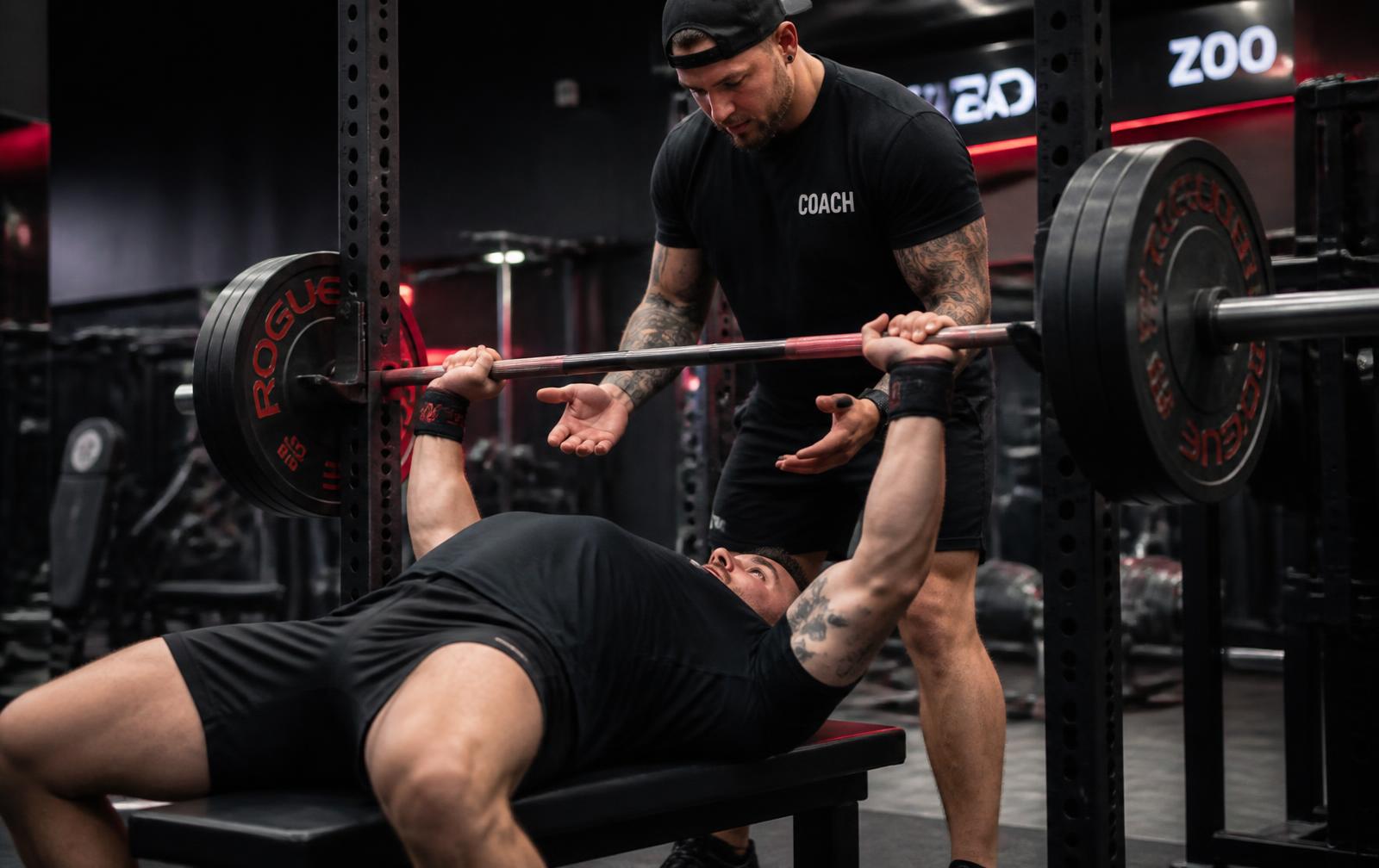 Coach spotting a lifter during a bench press